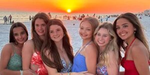 Six teen girls enjoying a photoshoot on Miramar Beach in front of the Hilton SanDestin Golf Resort and Spa in Destin, Florida