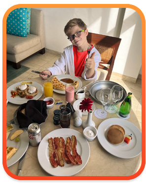 Young boy enjoying room service from his hotel suit at the Grand Fiesta Americana Coral Beach All Inclusive Spa Resort in Cancun, Mexico.